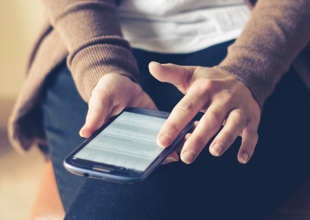 A close-up image of a person's using a smartphone.