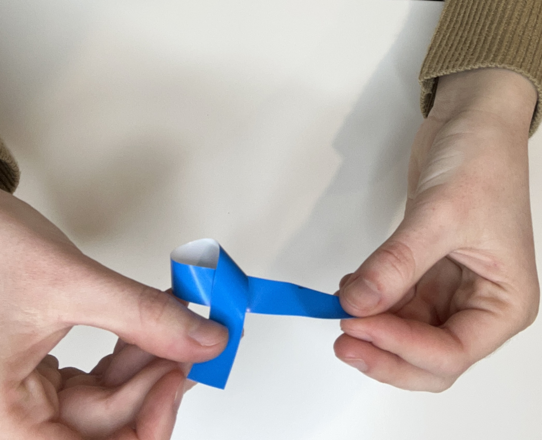 Blue strip of paper making a loop. 