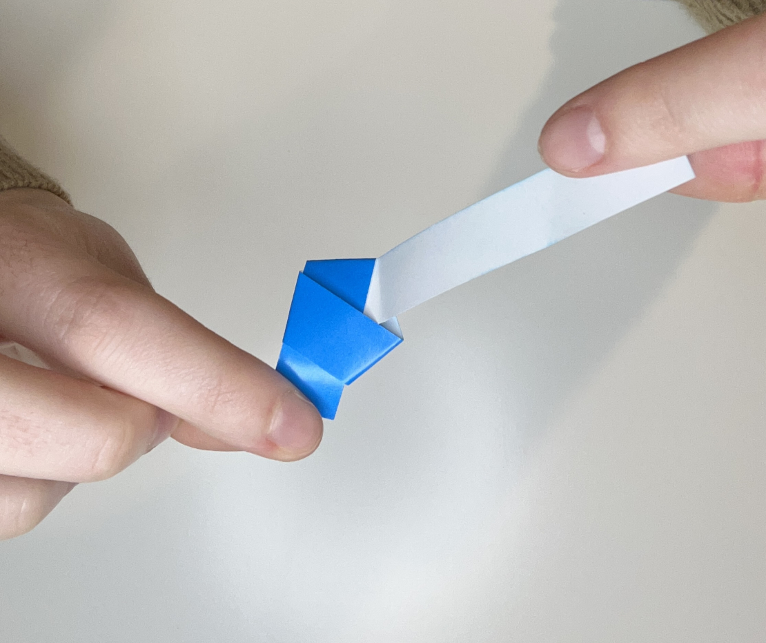 Strip being folded around the pentagon to make star shape.