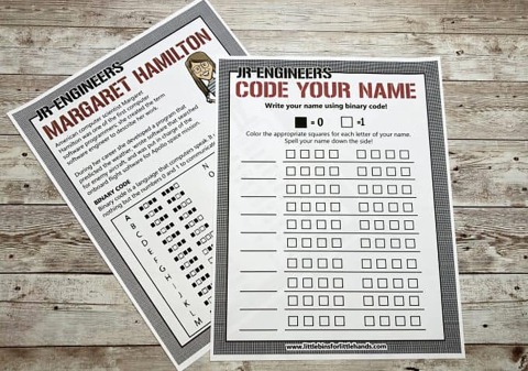 On a barn plank background, two sheets of paper are overlapped: bottom is a binary code letter legend, on top is a form to spell your name using the legend. 