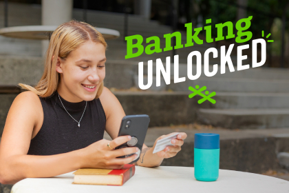 A female teen checks her bank account online on her phone.
