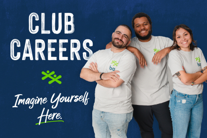 A group of three happy employees standing together and smiling.